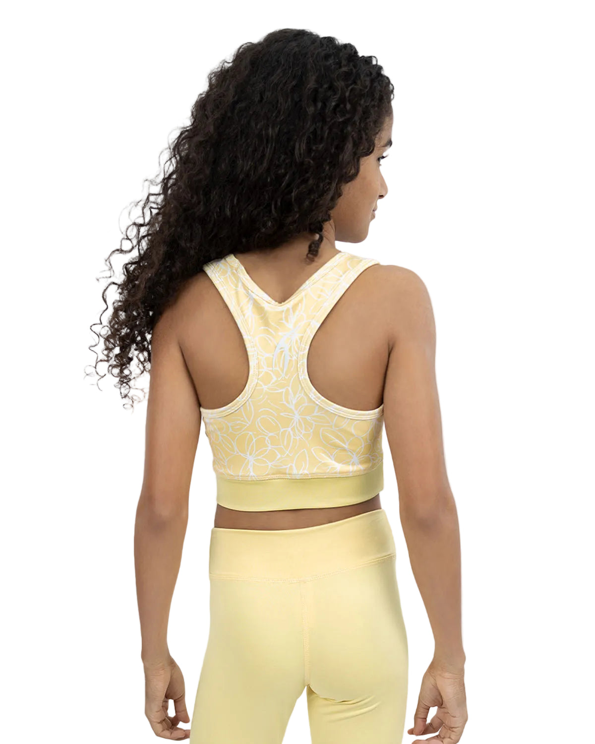 Woman wearing a yellow sports bra and leggings set on a light gray background